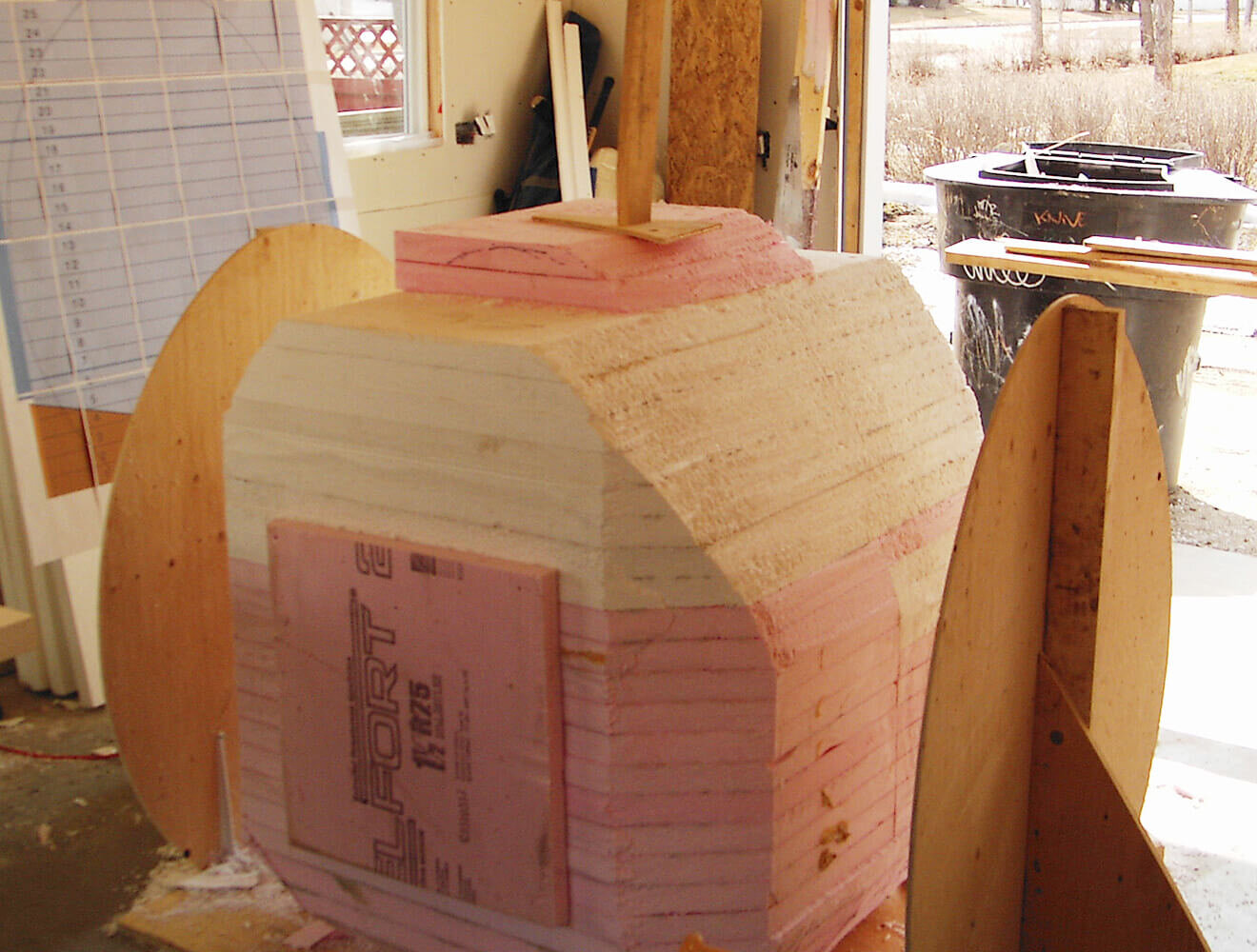 Once the plans were drawn and confirmed, the next step was laminating rigid foam sheets into a giant block. This block was then placed on a peg with egg shaped plywood templates on either side, creating a giant ‘lathe’.