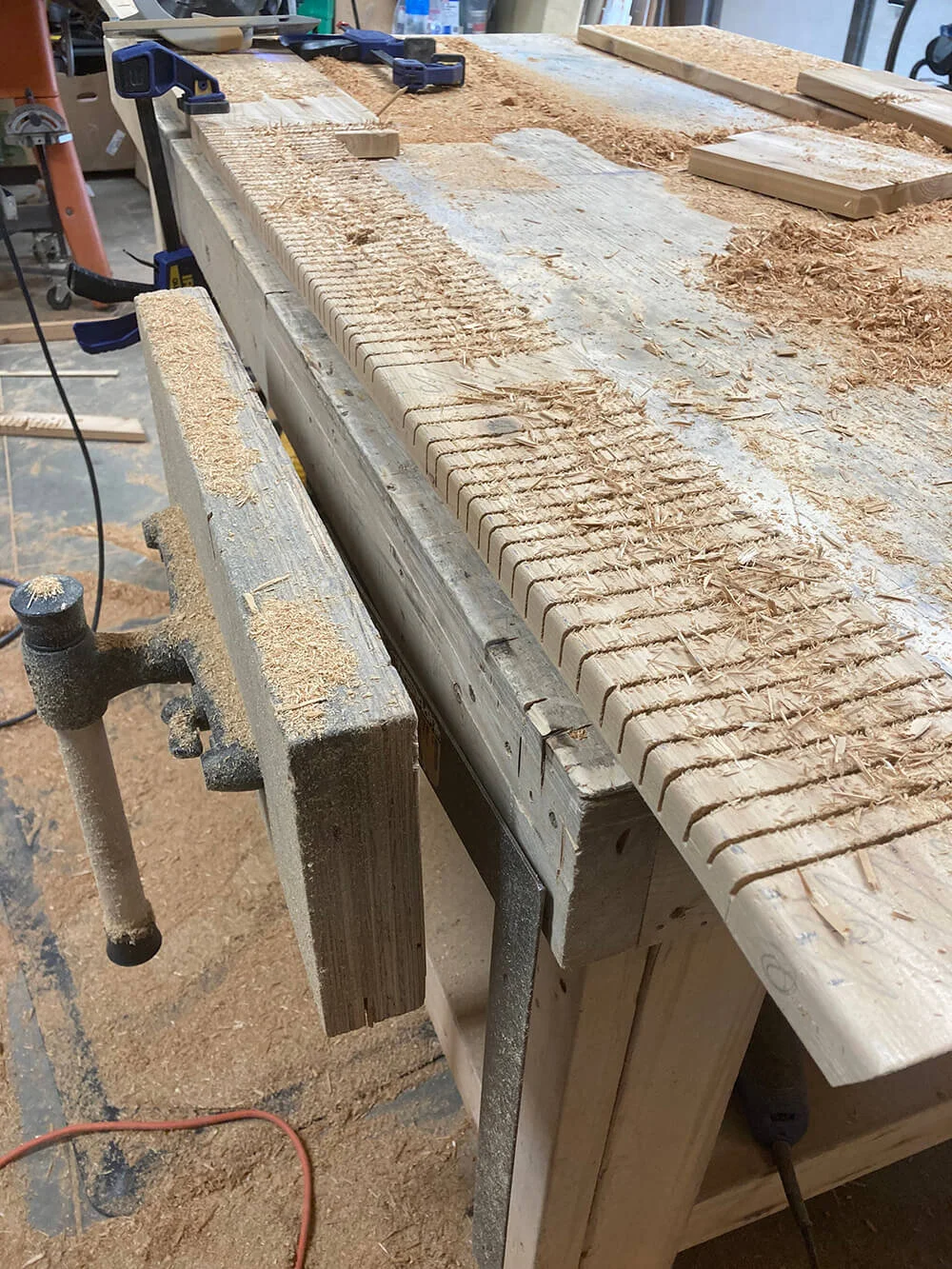 This is one of the skirt pieces showing 'kerf' relief cuts to enable bending. Where the skirt meets each joist end plate, the board has no cuts; this is so that the screws can be driven into solid material from the back. Note that approaching each s