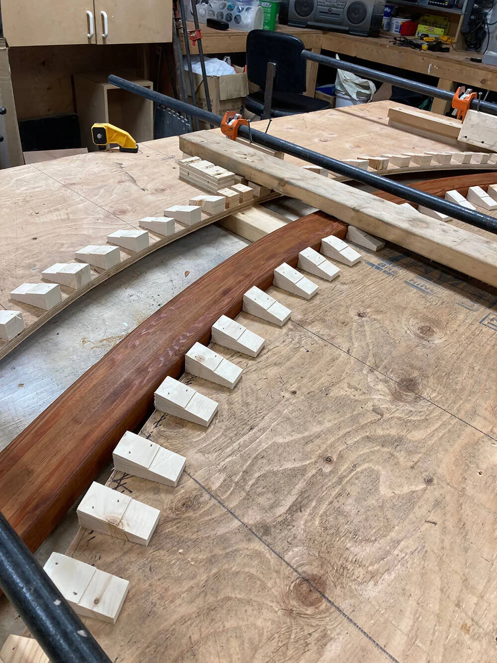 Here are the wet strips of clear cedar are being pressed. This is the pre-press before glue-up: One day wet press, 2 days drying out of the press under tension, then cleaned with acetone, epoxy applied, and back into the press.