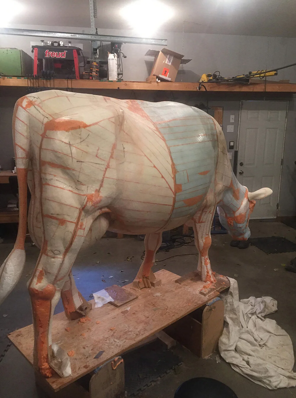 Now the shape is complete and a thin layer of fiberglass is on - with the exception of the feet, which come last. After this step is application of a lot of body filler, much of which I removed during shaping.