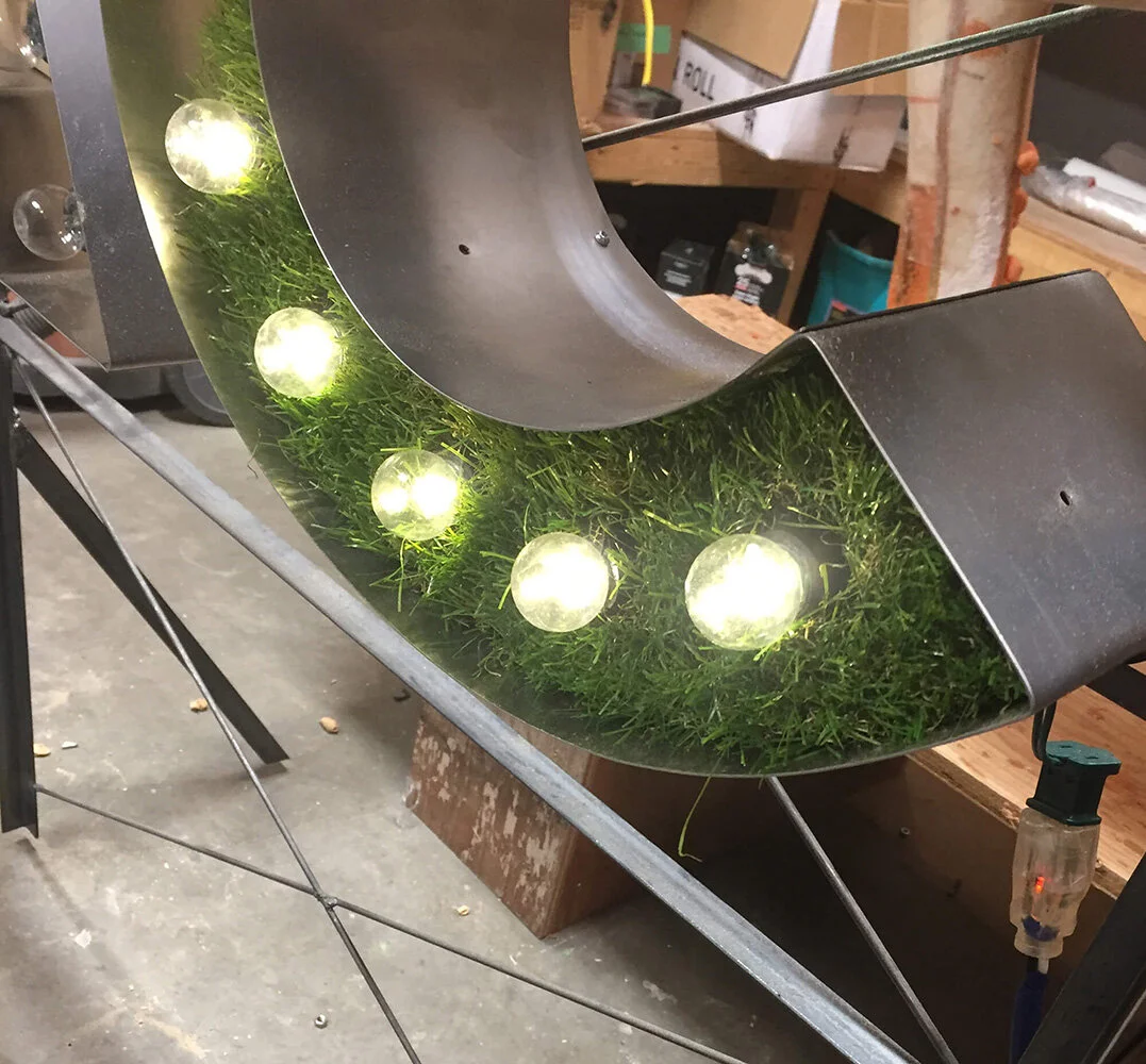 Here the finished letters with lights and grass in place are tested. These are LED and produce very little heat, allowing the use of materials for the sign that would not have been possible only a handful of years ago. Debra was hugely helpful with t